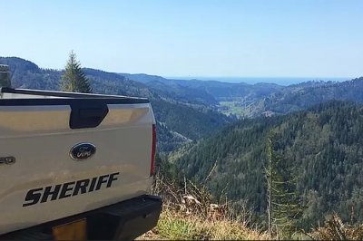 Back of Sheriff's truck overlooking forested hills
